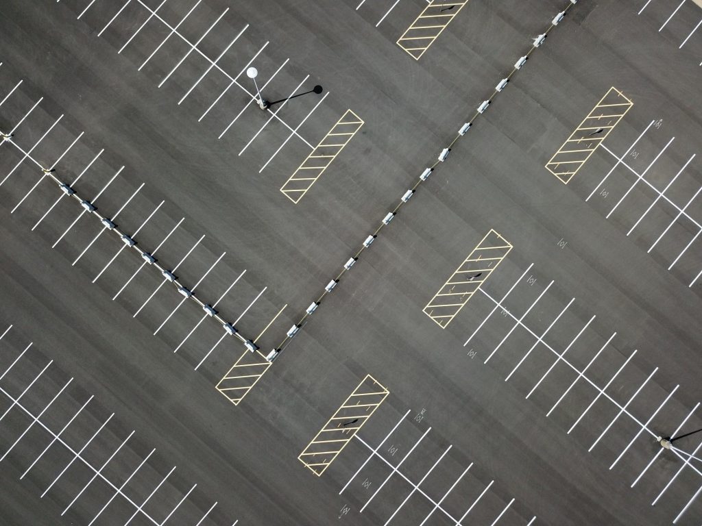 Aerial view of commercial parking lot striping and marked spaces